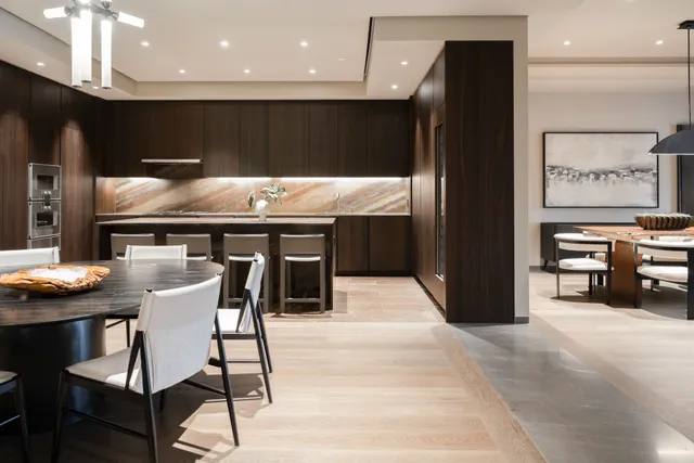 a kitchen with stainless steel appliances kitchen island granite countertop a table chairs sink and cabinets