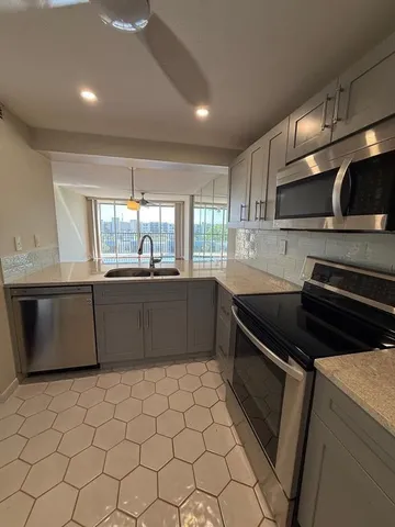 a kitchen with stainless steel appliances a sink stove and cabinets