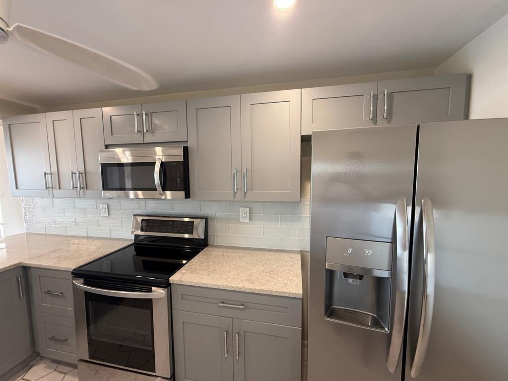 9 Royal Palm Way Boca Raton, FL 33432 - Photo 3 of 10 a kitchen with a refrigerator sink and microwave