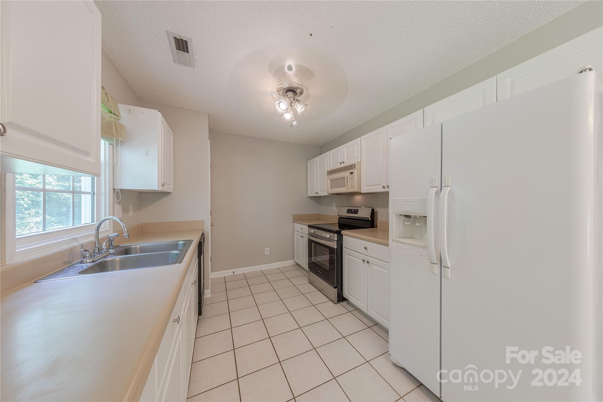 3230 McLendon Road Matthews, NC 28104 - Photo 12 of 29 a kitchen with stainless steel appliances a sink a stove a microwave and cabinets