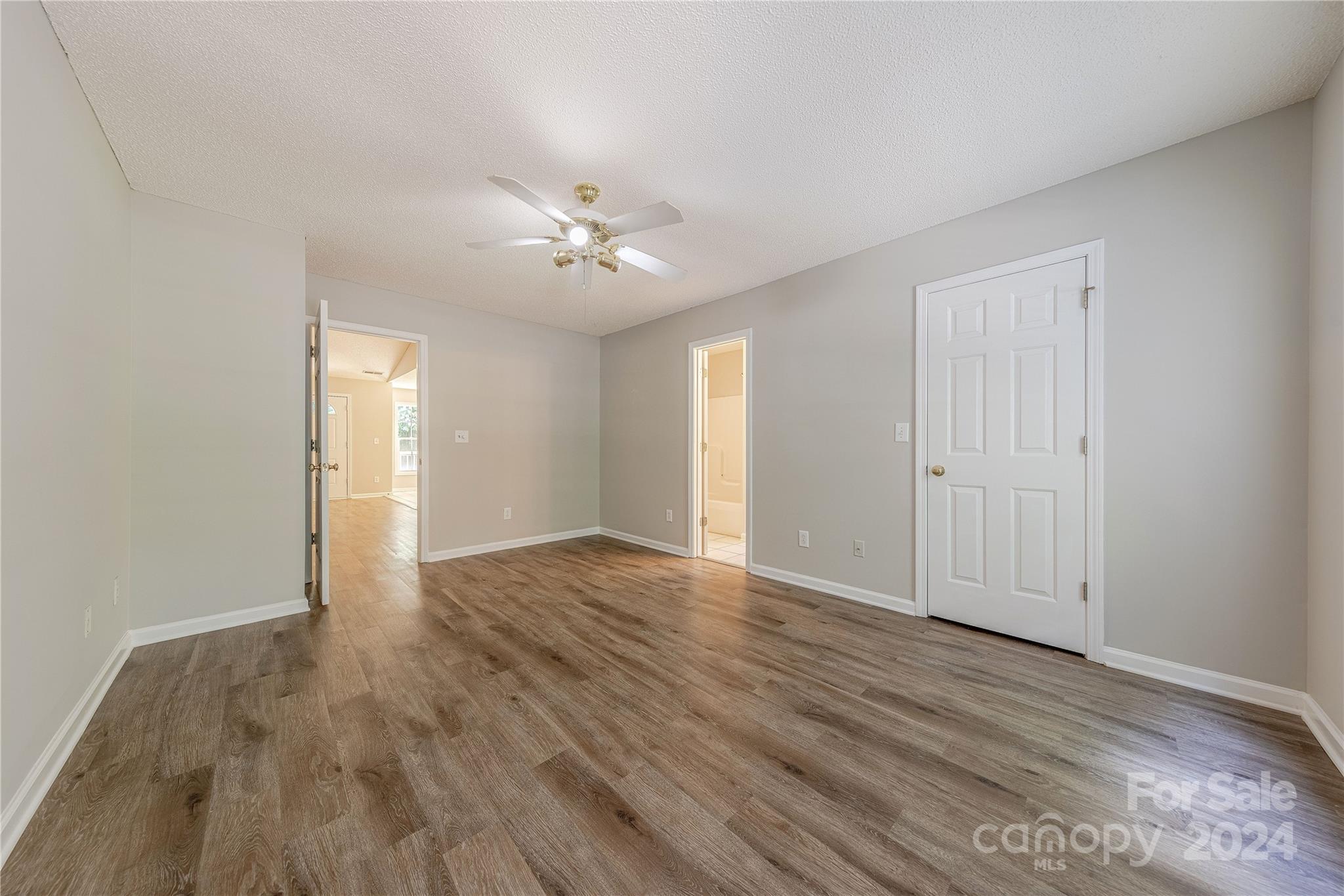 3230 McLendon Road Matthews, NC 28104 - Photo 16 of 29 a view of an empty room with wooden floor and a ceiling fan