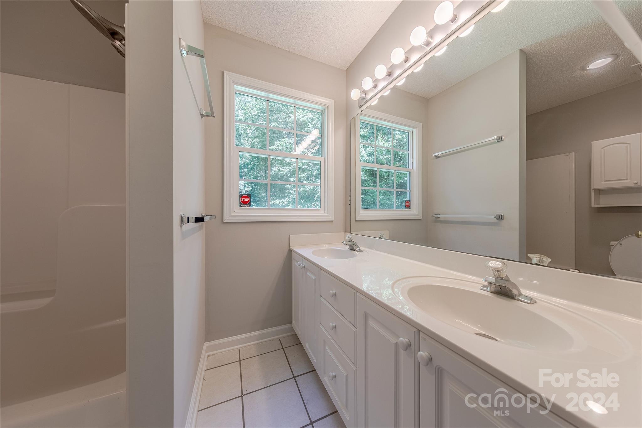 3230 McLendon Road Matthews, NC 28104 - Photo 17 of 29 a bathroom with a granite countertop sink a large mirror and a bathtub