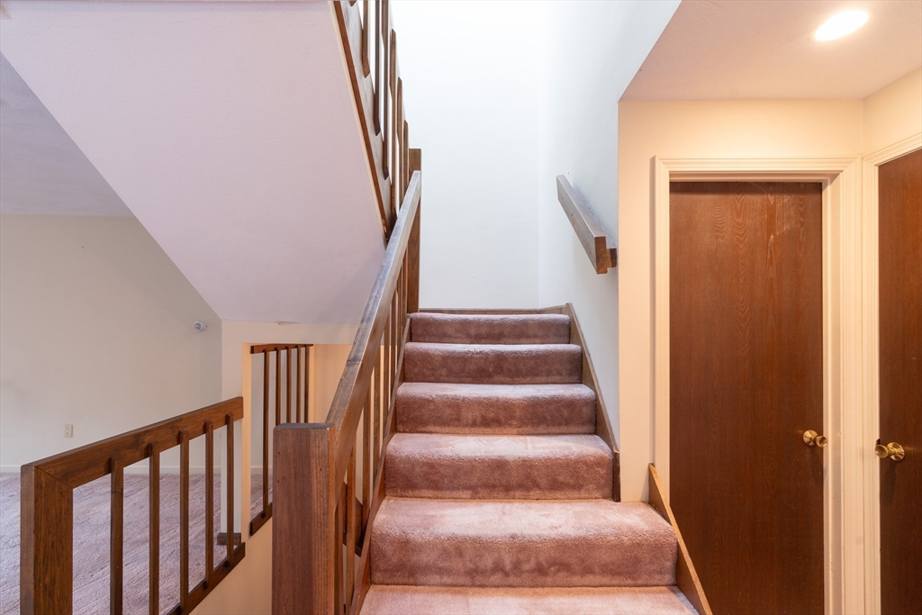 110 Mountain Gate Road, Unit 110 Ashland, MA 01721 - Photo 18 of 42 a view of staircase with lots of frames on wall