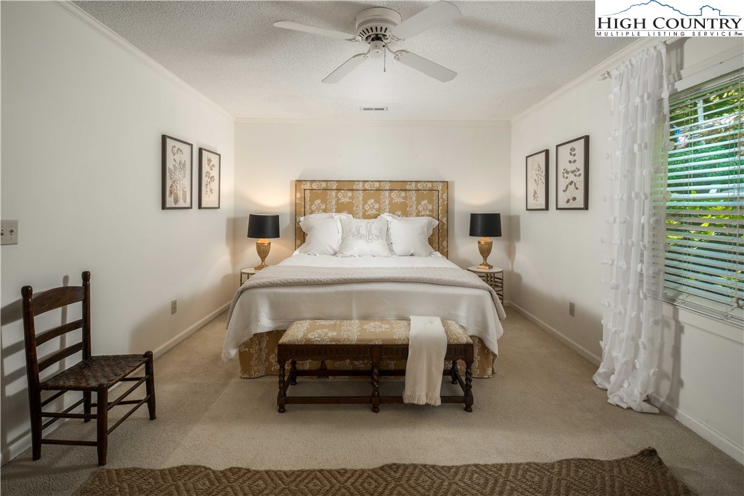 271 Pinnacle Avenue Blowing Rock, NC 28605 - Photo 21 of 43 a bedroom with a bed and a chandelier