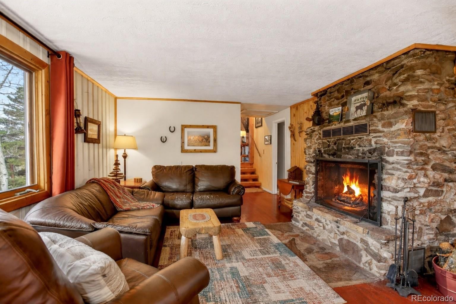 626 Aspen Lane Bailey, CO 80421 - Photo 13 of 47 a living room with furniture and a fireplace