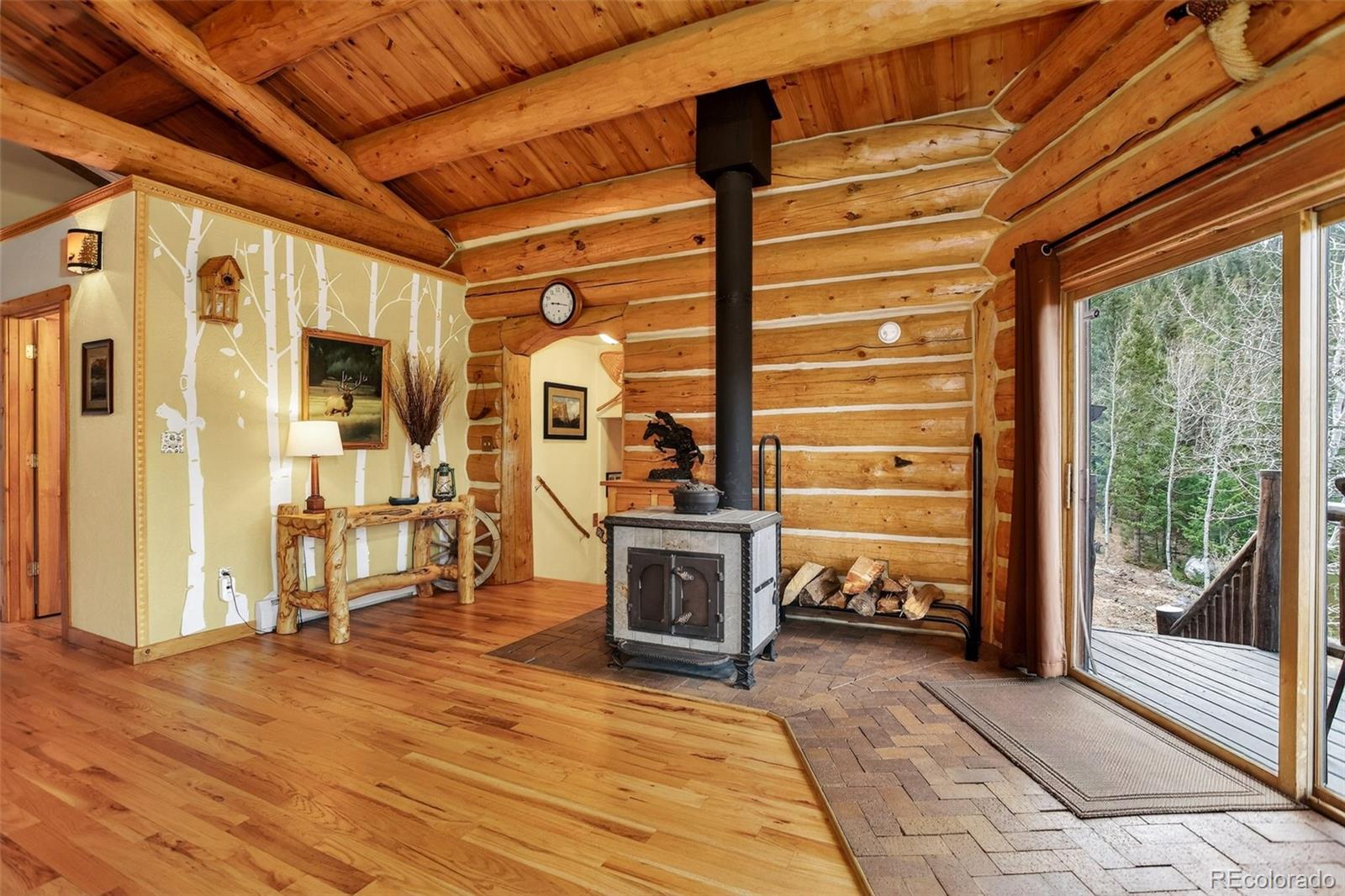626 Aspen Lane Bailey, CO 80421 - Photo 27 of 47 a view of a hallway with wooden floors and fireplace