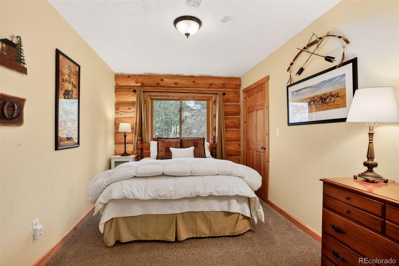 626 Aspen Lane Bailey, CO 80421 - Photo 30 of 47 a bedroom with a bed and dresser with mirror
