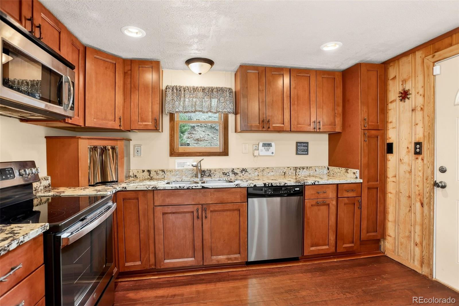 626 Aspen Lane Bailey, CO 80421 - Photo 7 of 47 a kitchen with stainless steel appliances granite countertop a stove a sink dishwasher and a microwave oven with wooden cabinets