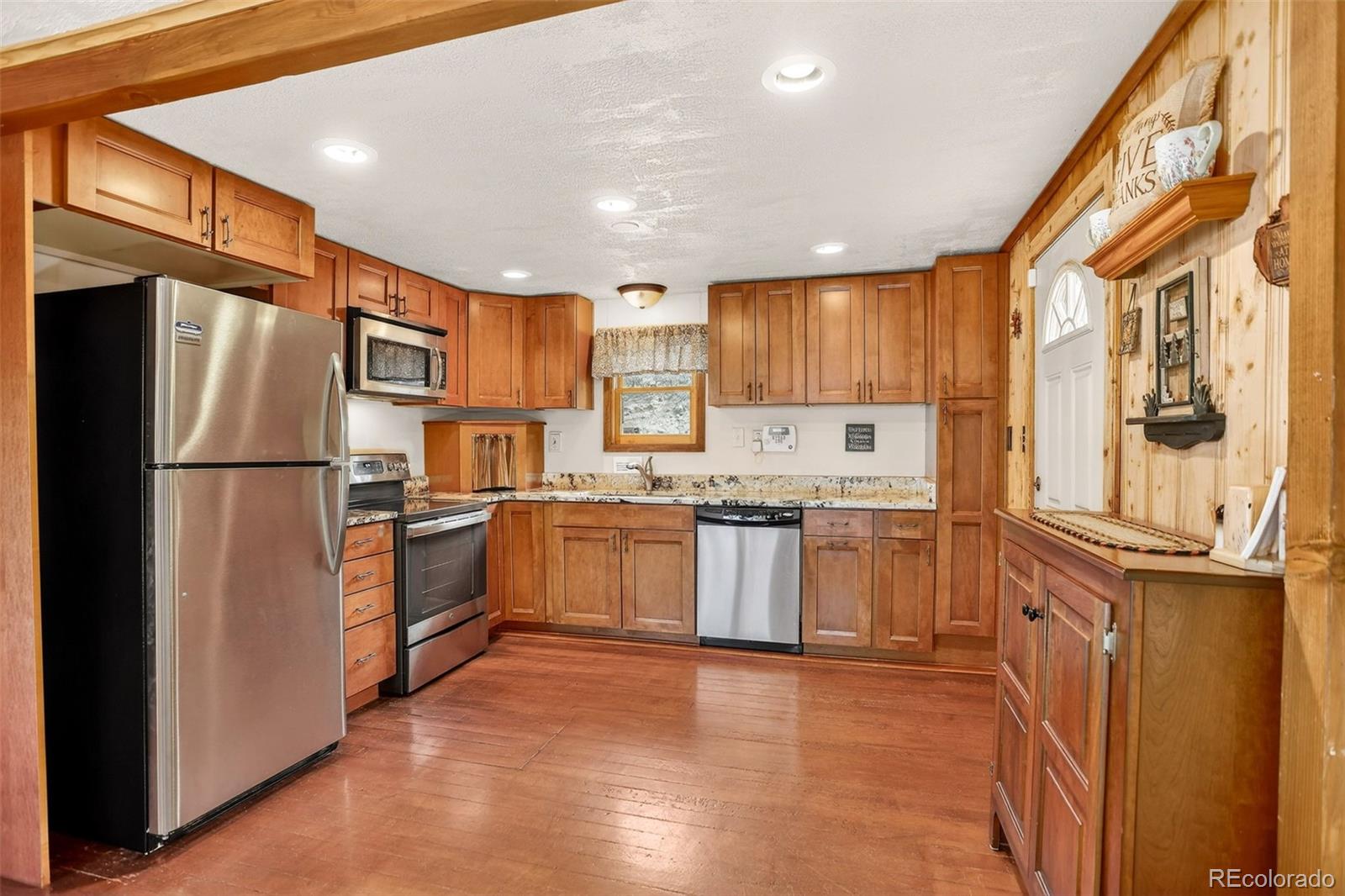 626 Aspen Lane Bailey, CO 80421 - Photo 8 of 47 a kitchen with a refrigerator a sink and cabinets