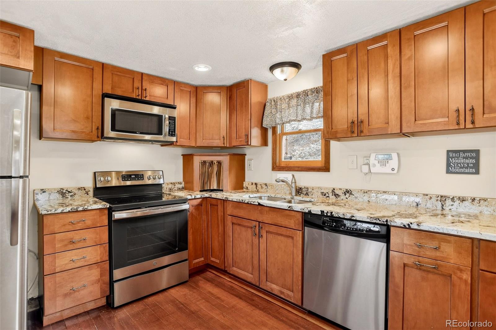 626 Aspen Lane Bailey, CO 80421 - Photo 9 of 47 a kitchen with stainless steel appliances granite countertop wooden cabinets a stove a sink and dishwasher