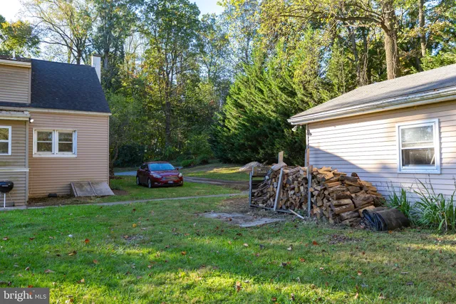 a view of a house with a big yard and large trees