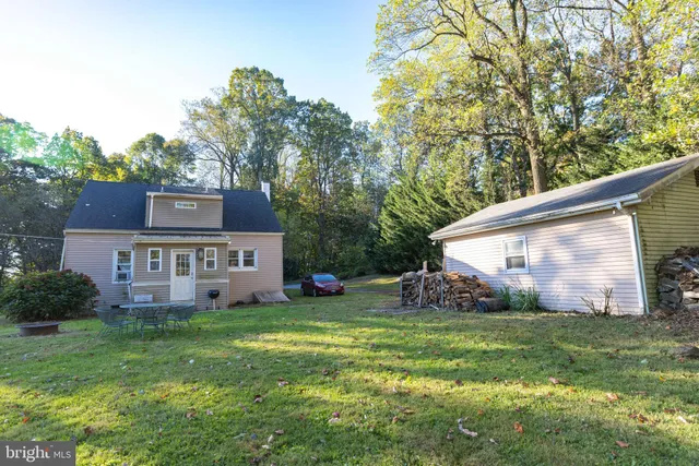 a view of a house with a yard and a large tree
