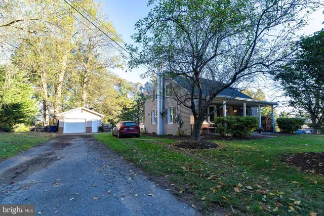 a front view of a house with a garden and trees