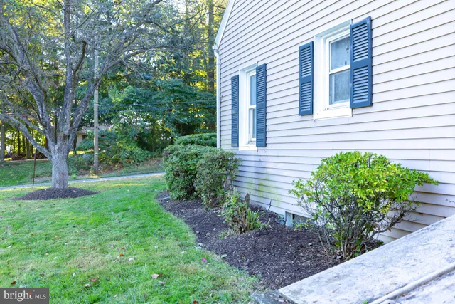 a view of backyard of house with wooden deck and seating space