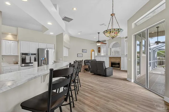 a view of a dining room and livingroom with furniture wooden floor a chandelier