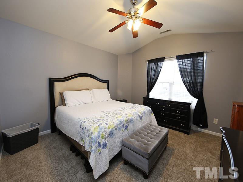 3808 Watkins Ridge Court Raleigh, NC 27616 - Photo 14 of 22 a bedroom with a bed rug and dresser