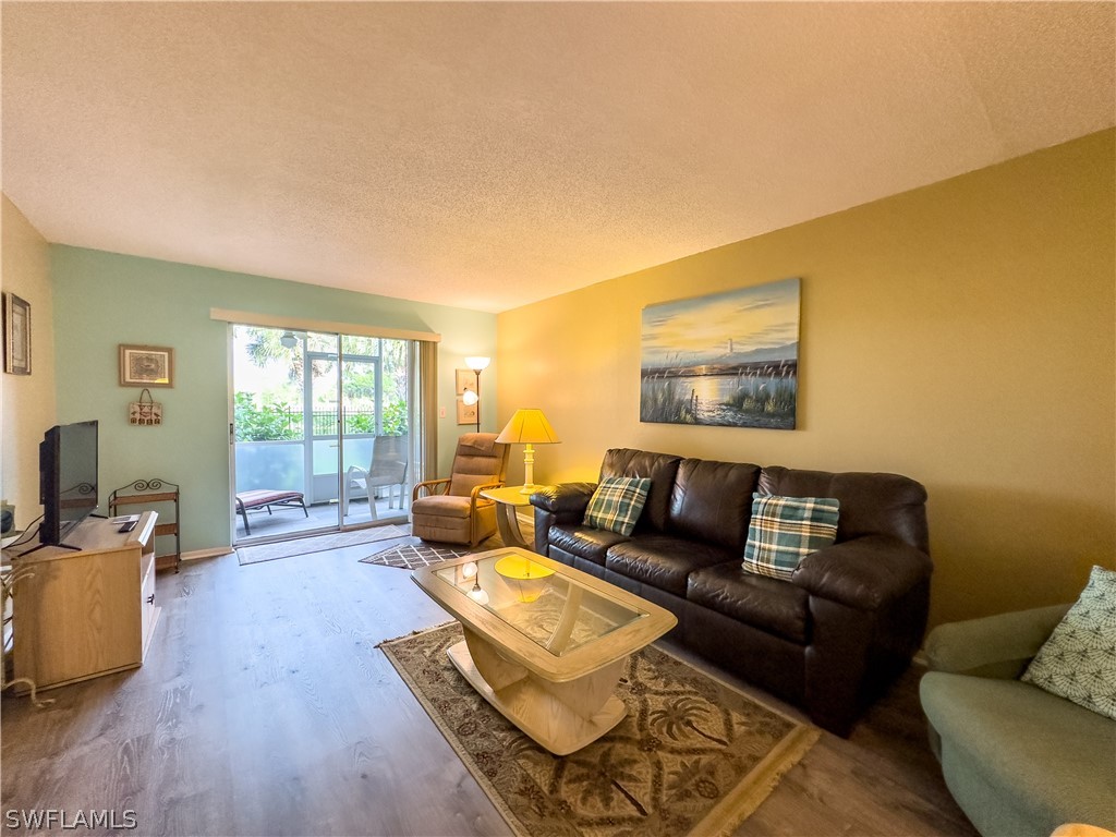 6777 Winkler Road, Unit 168 Fort Myers, FL 33919 - Photo 11 of 37 a living room with furniture and a flat screen tv with wooden floor