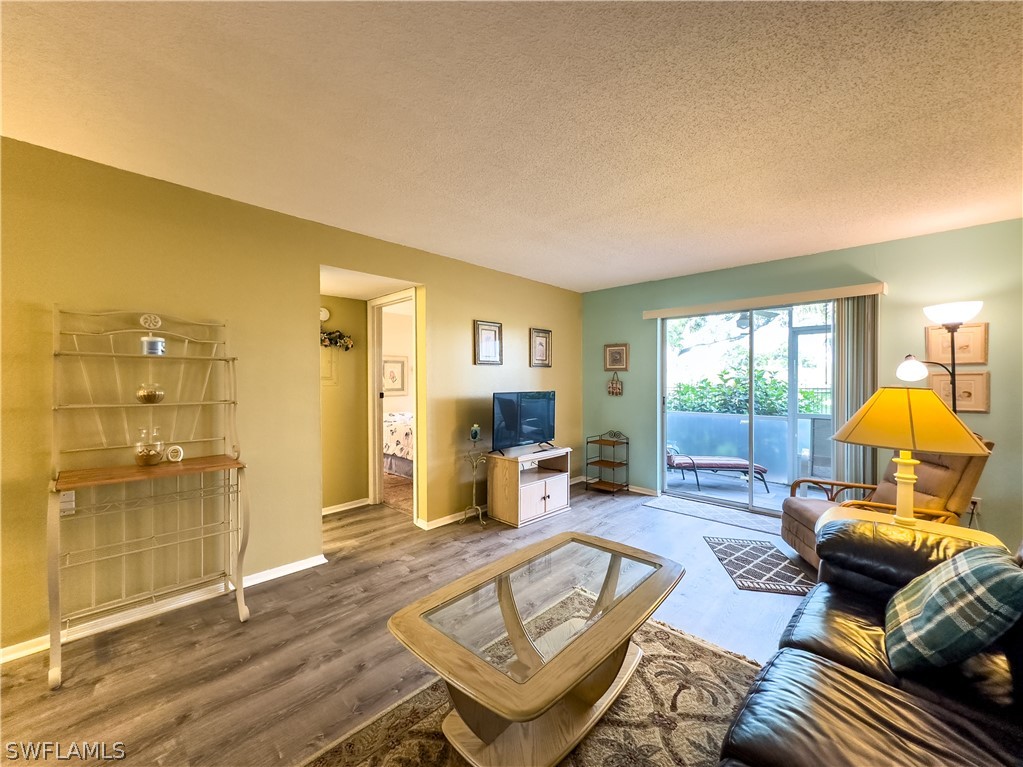 6777 Winkler Road, Unit 168 Fort Myers, FL 33919 - Photo 14 of 37 a living room with furniture and a wooden floor