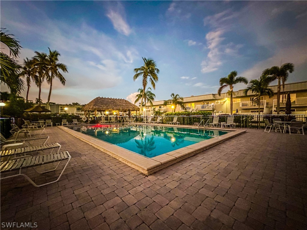 6777 Winkler Road, Unit 168 Fort Myers, FL 33919 - Photo 31 of 37 a swimming pool with outdoor seating and a garden