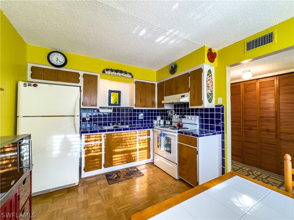 6777 Winkler Road, Unit 168 Fort Myers, FL 33919 - Photo 7 of 37 a kitchen with stainless steel appliances granite countertop a stove and a refrigerator