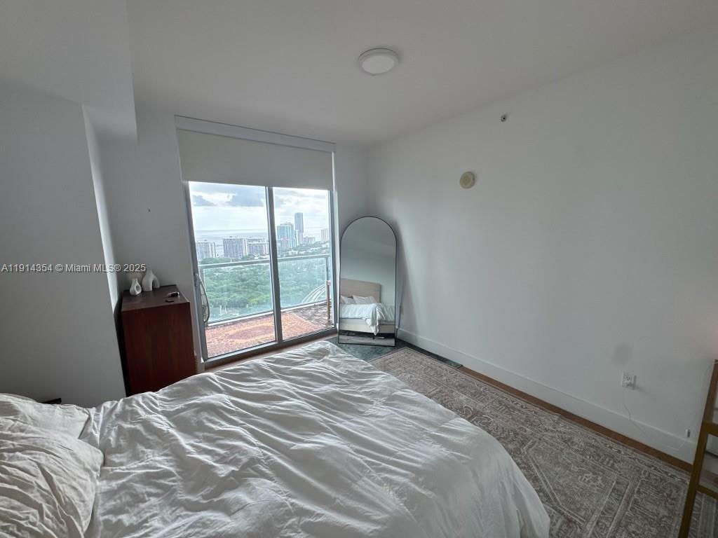 79 Southwest 12th Street, Unit 3601S Miami, FL 33130 - Photo 15 of 27 a bedroom with a bed and a large window