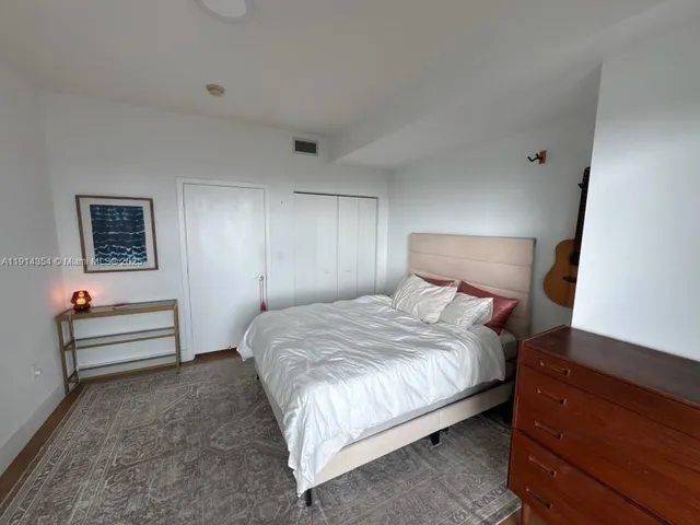 a bedroom with a bed and a night stand