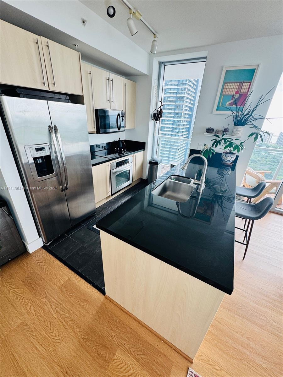 79 Southwest 12th Street, Unit 3601S Miami, FL 33130 - Photo 9 of 27 a kitchen with stainless steel appliances kitchen island granite countertop a refrigerator a stove a sink and a stove