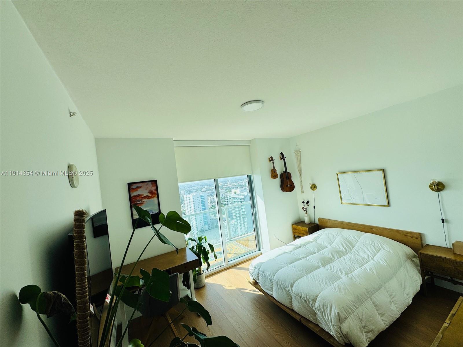 79 Southwest 12th Street, Unit 3601S Miami, FL 33130 - Photo 10 of 27 a bedroom with a bed and wooden floor