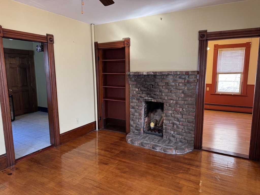 93 Cross Street Gardner, MA 01440 - Photo 15 of 35 a view of an empty room with wooden floor fireplace and a window