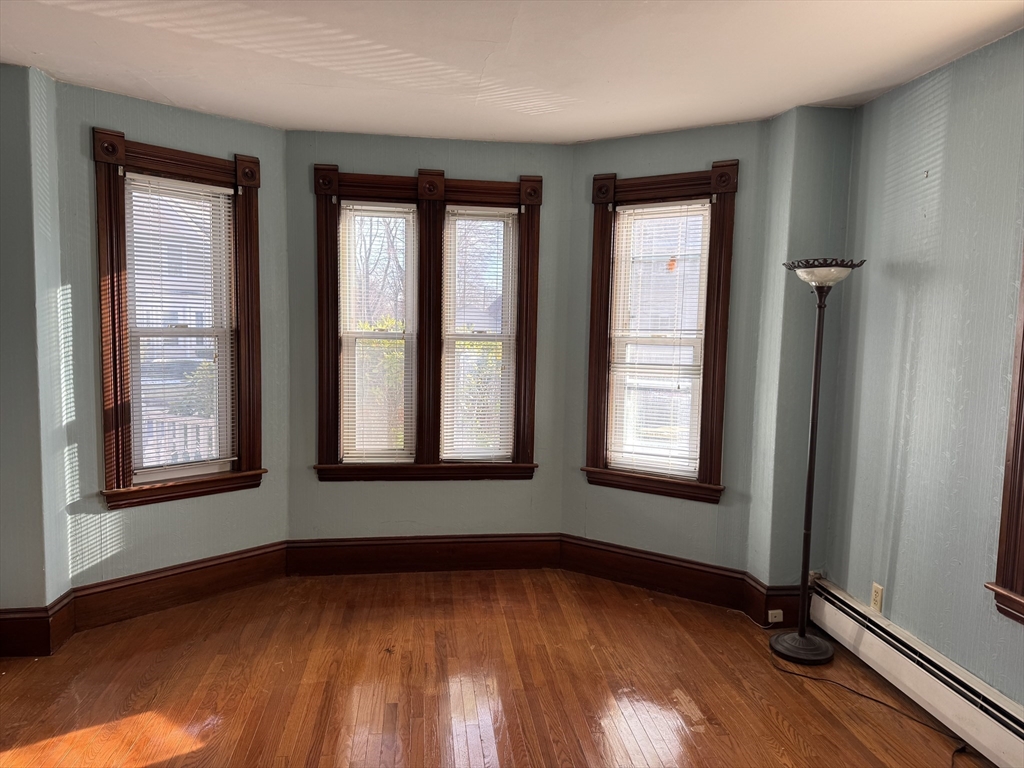 93 Cross Street Gardner, MA 01440 - Photo 8 of 35 a view of an empty room with wooden floor and a window
