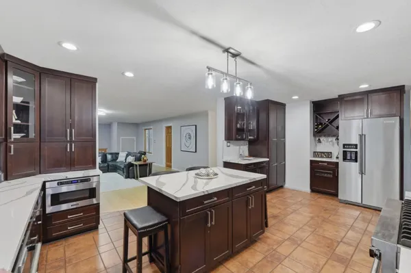 a kitchen with kitchen island a sink stove and refrigerator
