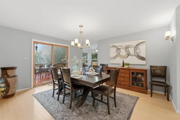 a dining room with furniture a chandelier and wooden floor