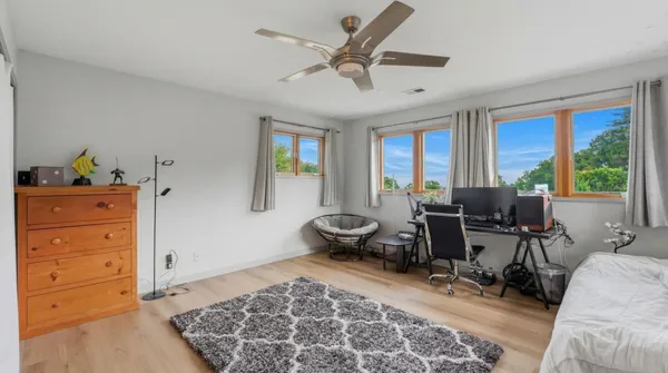 a bedroom with furniture and a large window