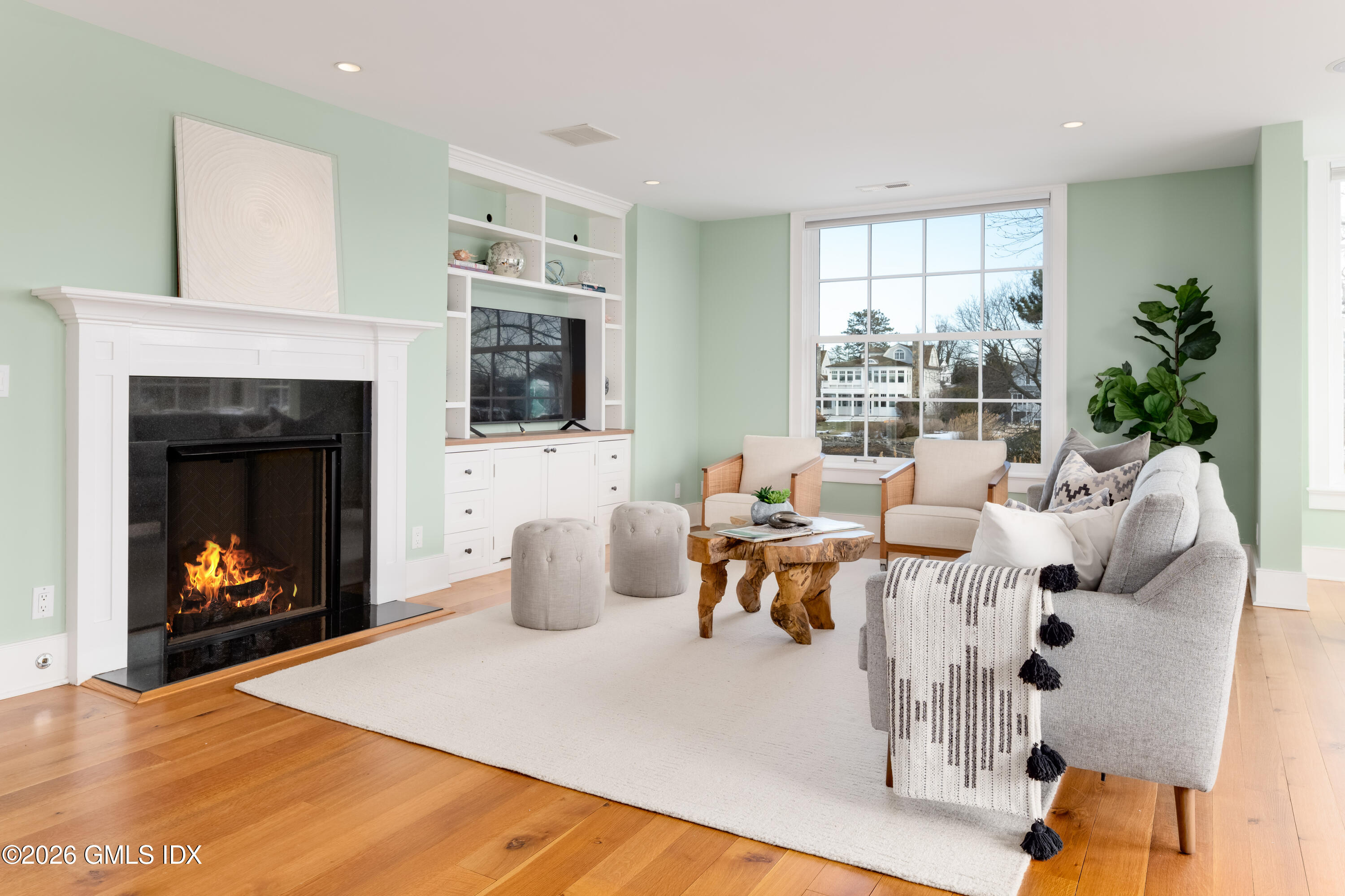 189 Shore Road Old Greenwich, CT 06870 - Photo 13 of 38 a living room with furniture potted plant a fireplace and a window