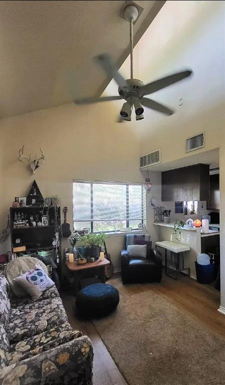 Living room featuring wood finished floors, a ceiling fan, and high vaulted ceiling