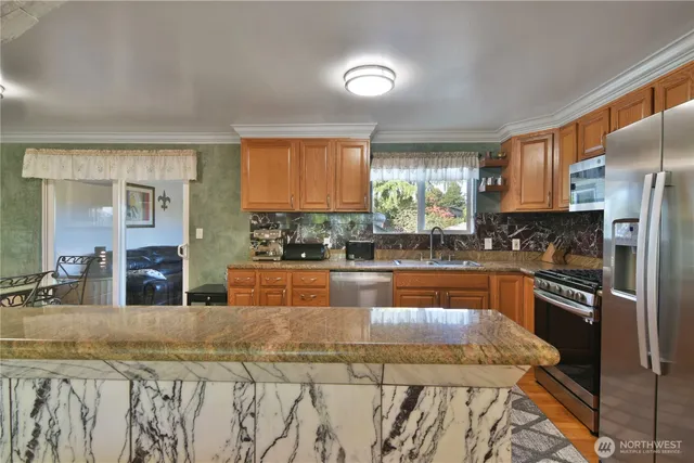 a kitchen with stainless steel appliances granite countertop a stove a sink and a refrigerator