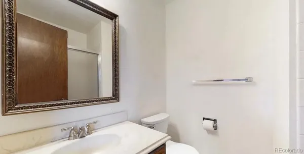 a bathroom with a sink and mirror with toilet