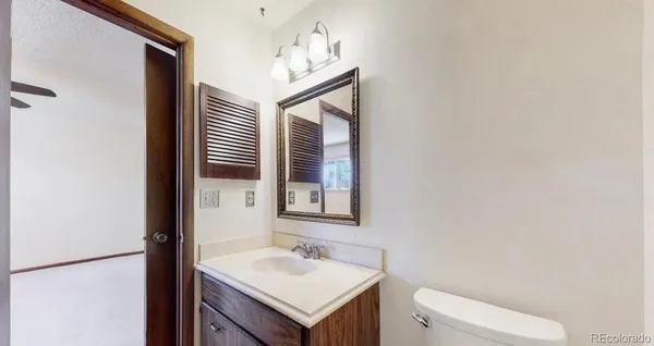 a bathroom with a toilet sink and mirror