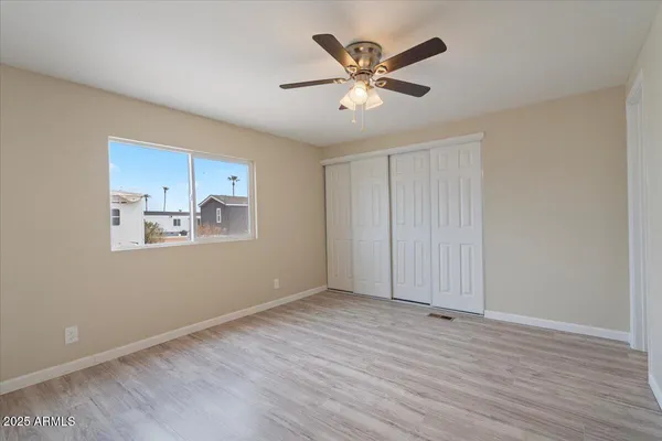 a view of empty room with wooden floor and window