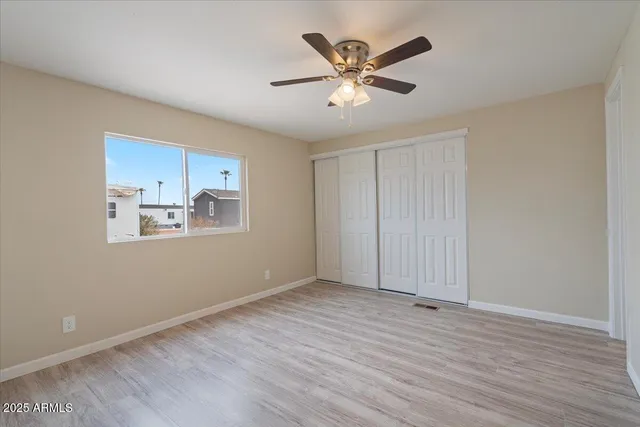 a view of empty room with wooden floor and window