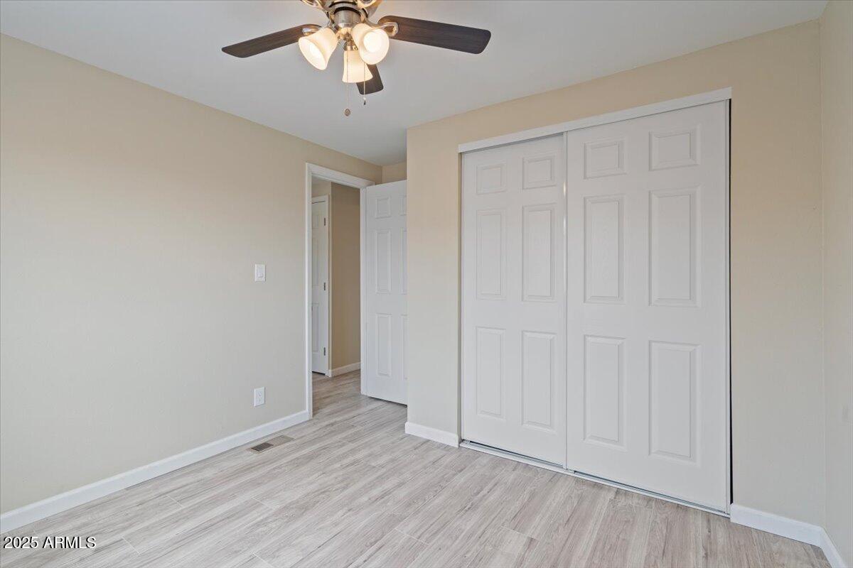 320 East McKellips Road, Unit 209 Mesa, AZ 85201 - Photo 21 of 25 an empty room with wooden floor closet and windows