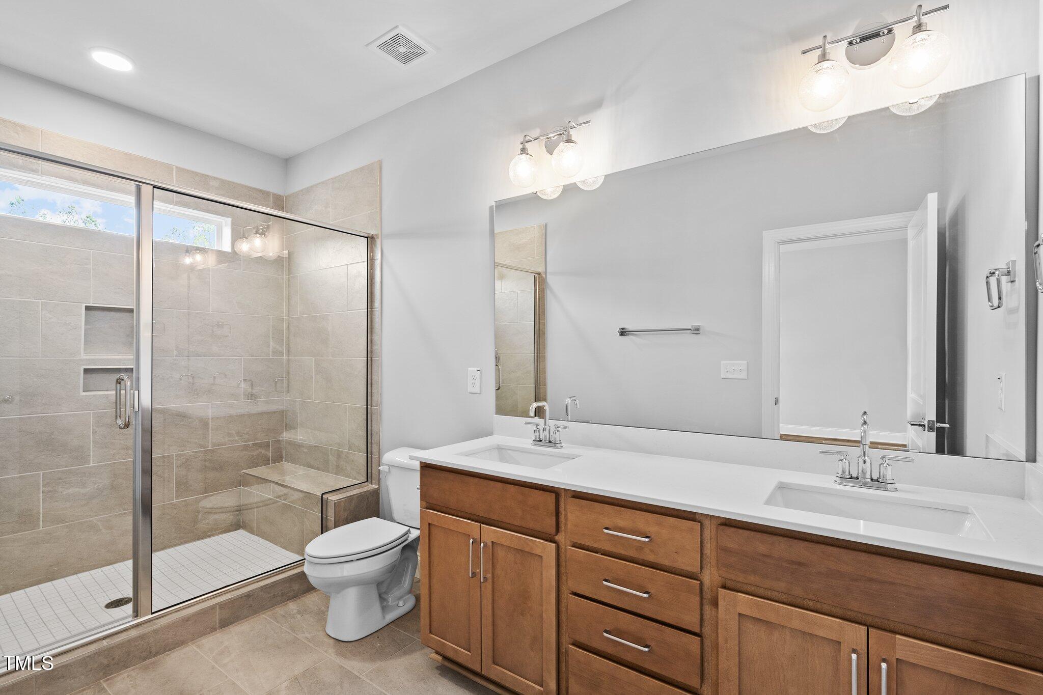 703 Jamescroft Way, Unit 13 Rolesville, NC 27571 - Photo 11 of 36 a bathroom with a double vanity sink toilet and shower