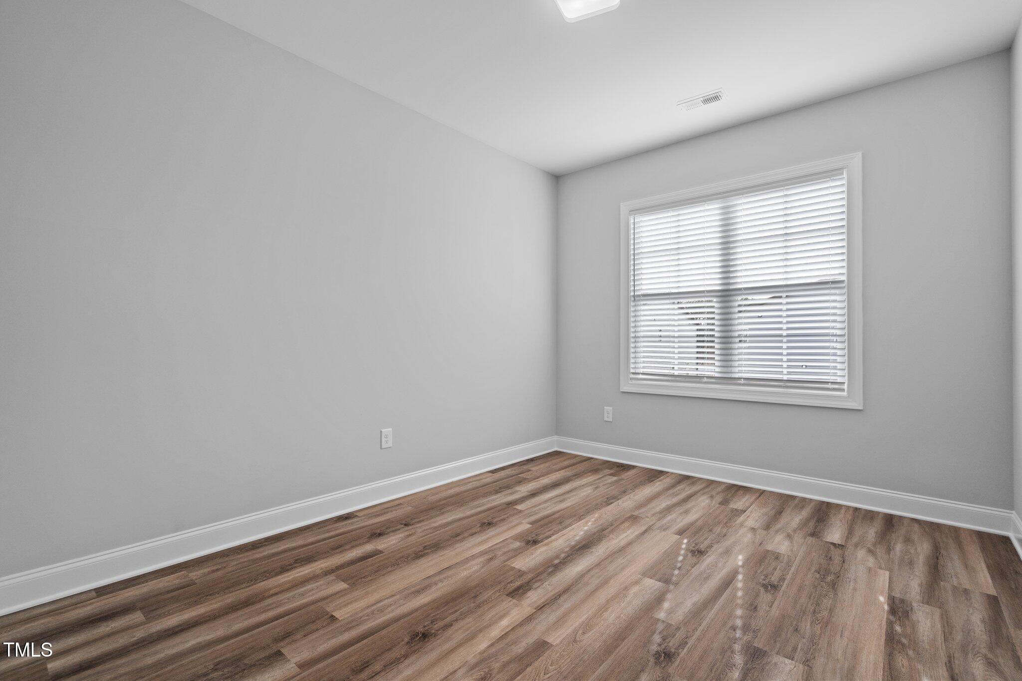 703 Jamescroft Way, Unit 13 Rolesville, NC 27571 - Photo 14 of 36 wooden floor in an empty room with a window