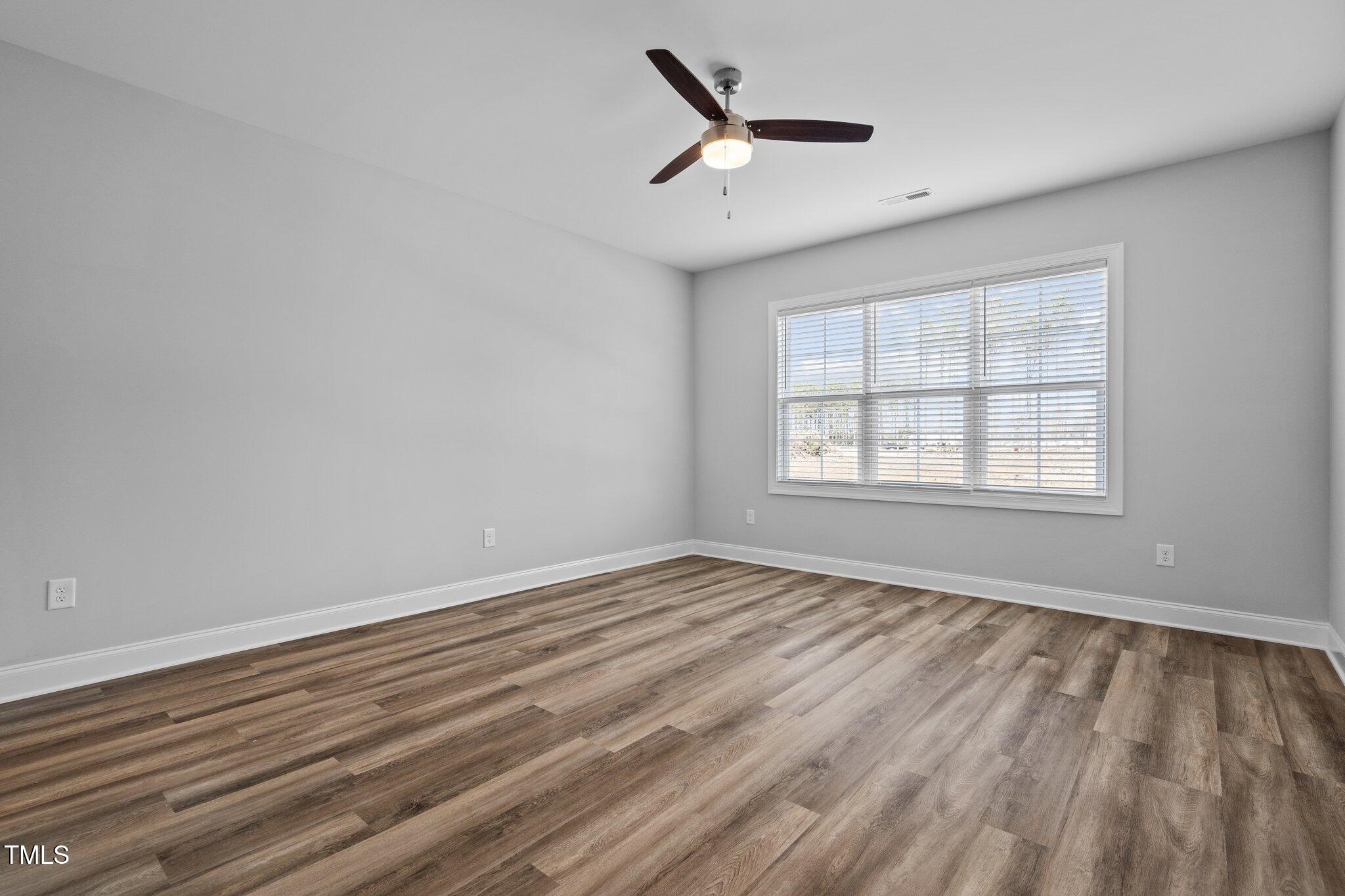 703 Jamescroft Way, Unit 13 Rolesville, NC 27571 - Photo 9 of 36 wooden floor in an empty room with a window