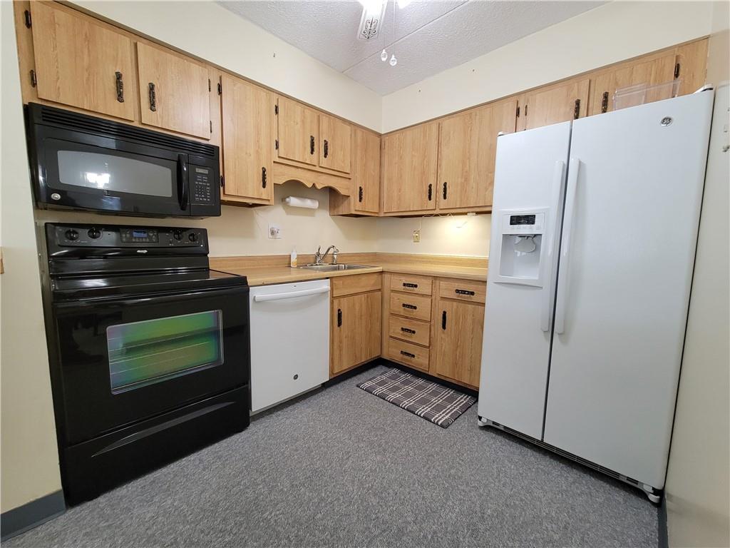 2120 Greentree Road, Unit 100E Pittsburgh, PA 15220 - Photo 8 of 25 a kitchen with stainless steel appliances a stove a microwave and a refrigerator