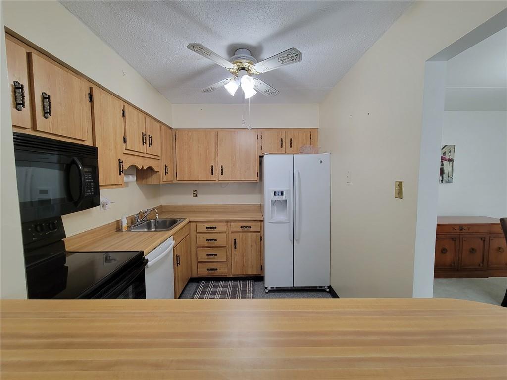 2120 Greentree Road, Unit 100E Pittsburgh, PA 15220 - Photo 9 of 25 a kitchen with stainless steel appliances kitchen island a refrigerator sink and cabinets