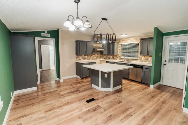 a open kitchen with a sink stove and wooden floor