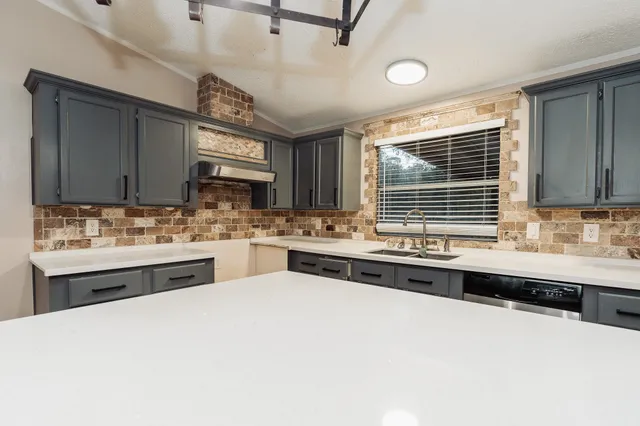 a large white kitchen with a sink and cabinets