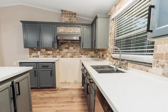 a kitchen with a sink stove and cabinets