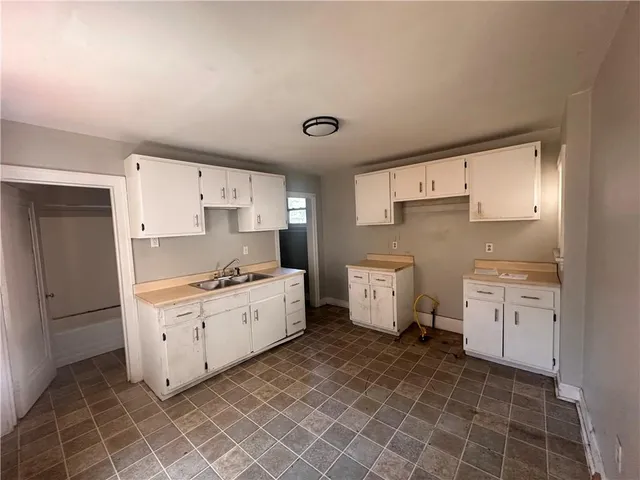 a large white kitchen with a stove a sink dishwasher and a refrigerator